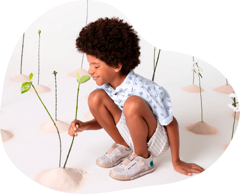 Child planting a seedling, wearing Bibi shoes