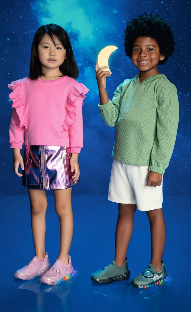 Two kids with light-up shoes holding a glowing moon